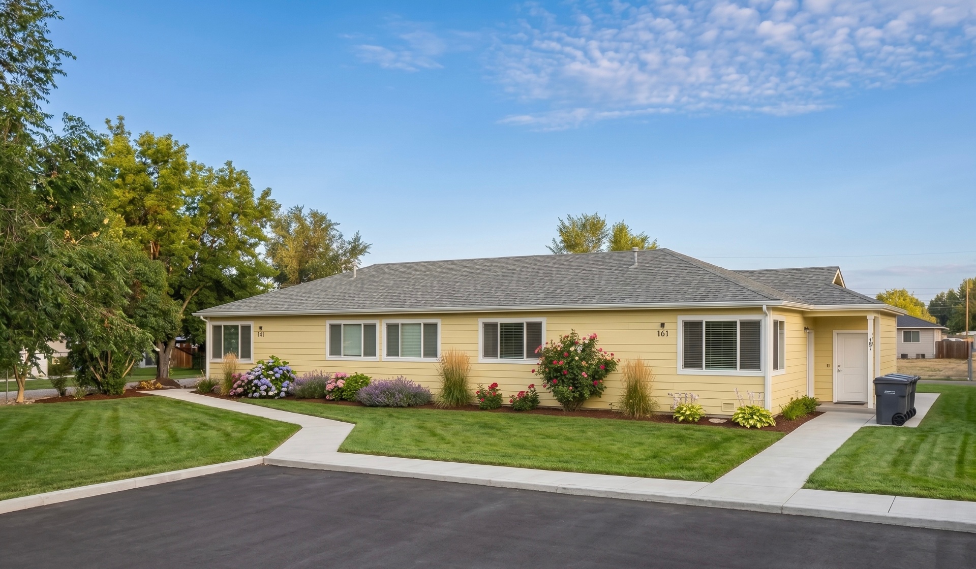 Rising Sun Twin Falls yellow ranch home with manicured landscaping