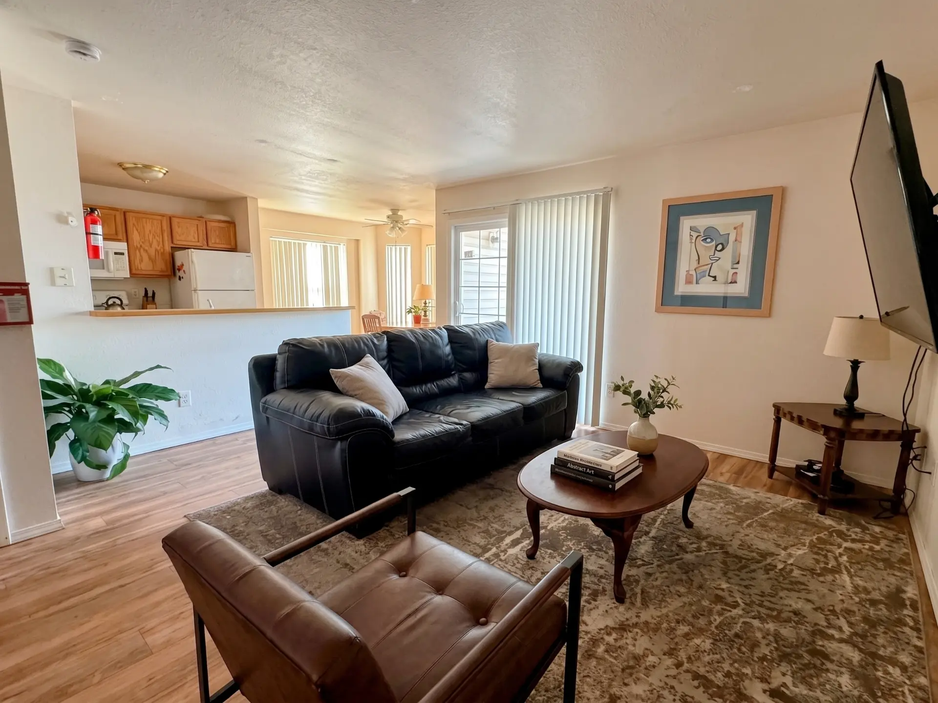 Living room in a Rising Sun private rental with a leather sofa, armchair, area rug, and wall-mounted television