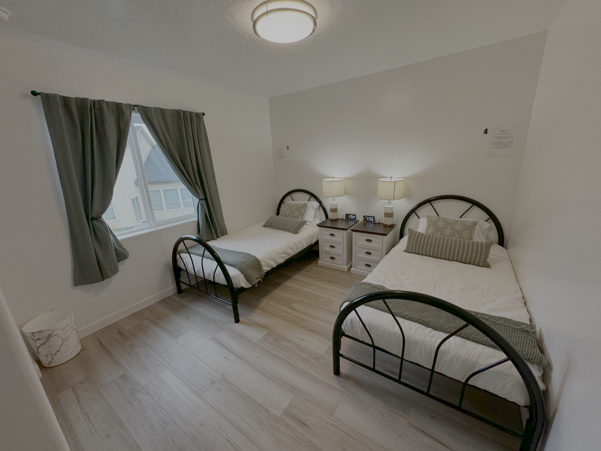 Rising Sun resident bedroom with two twin beds, nightstands, and natural window light