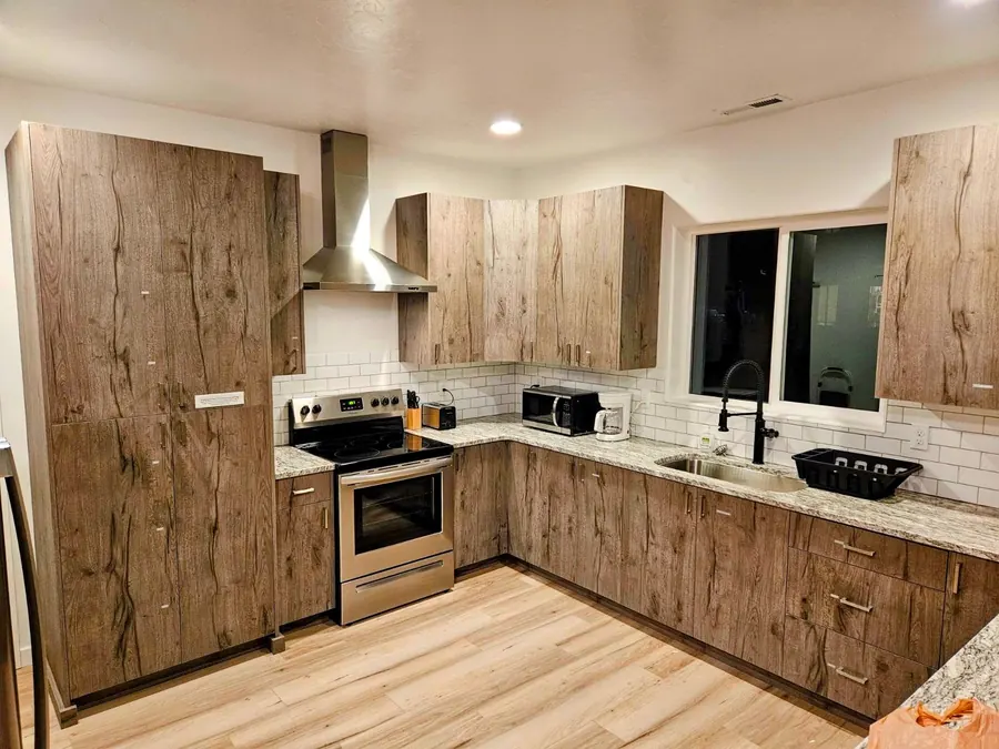 Rising Sun shared kitchen with white cabinetry, gas range, and dining counter